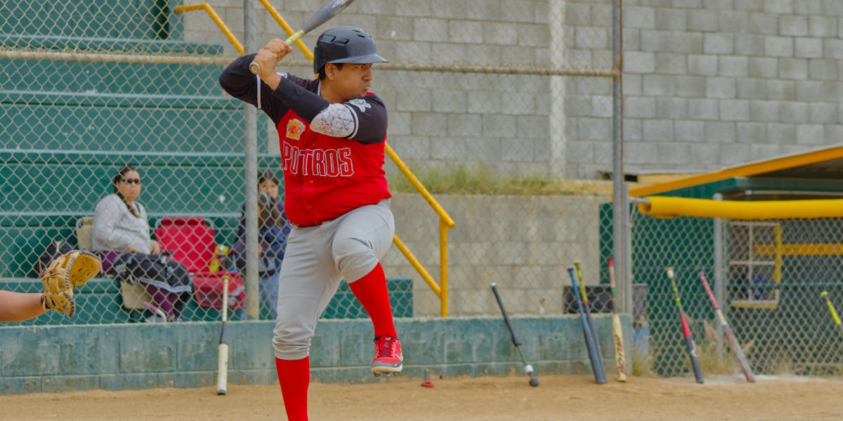 Softball player and bat certification guide context on a diamond.