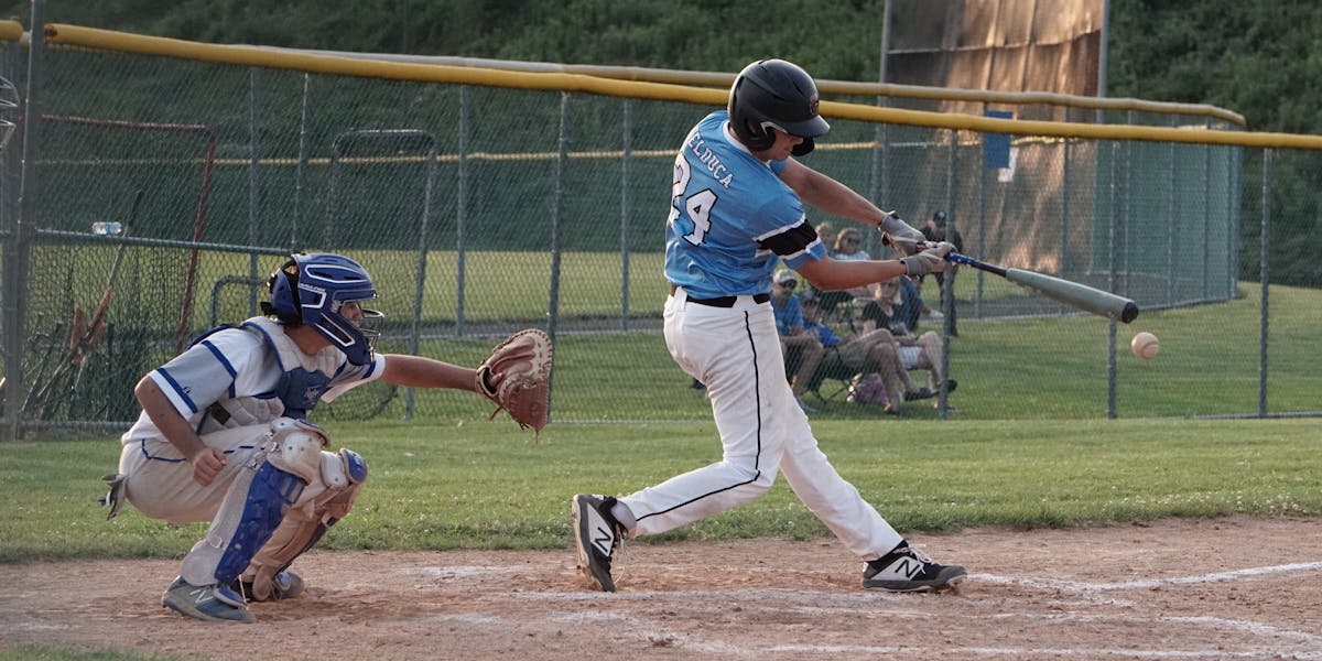 Action-packed baseball scene capturing the batter mid-swing with the catcher ready.