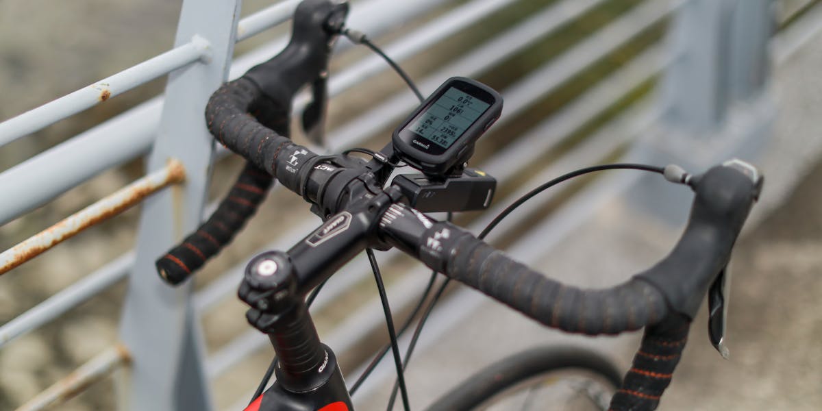 Close-up of a bicycle handlebar with a bike computer in Taipei's urban setting.