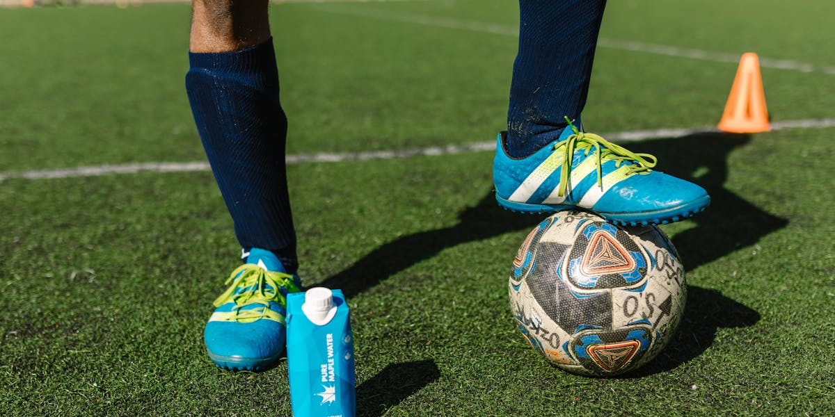 A focused view of a football player's feet wearing cleats on the field, ready fo