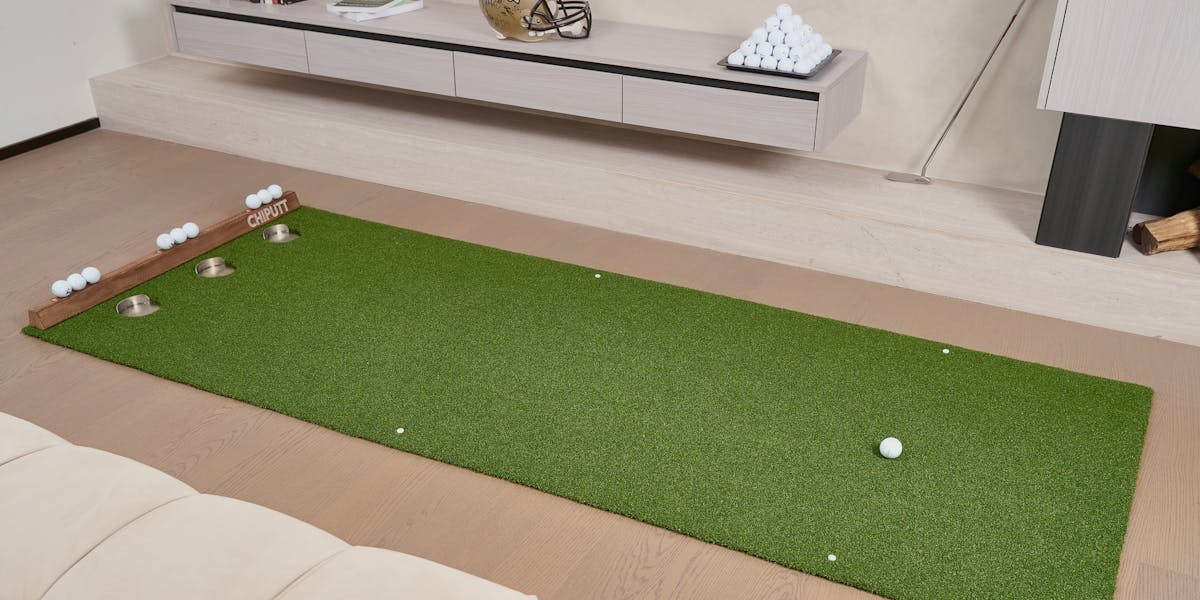 Indoor putting green with golf balls and equipment, perfect for practice at home.