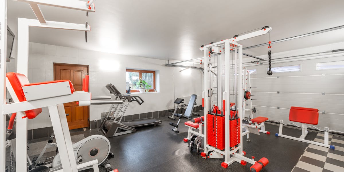 Modern interior design of new spacious fitness gym for home sport training and hea...