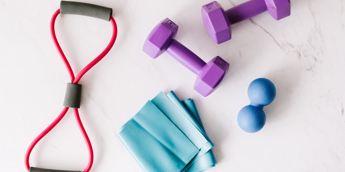 Colorful home workout equipment, including dumbbells and resistance bands, on a 