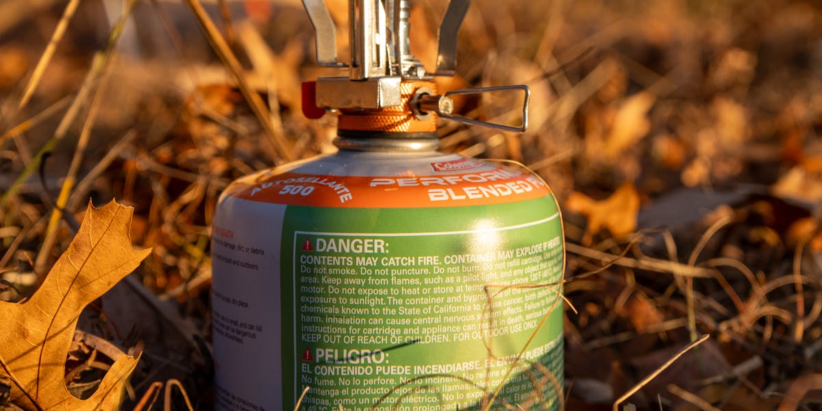 A portable camping stove setup in an autumn forest, ideal for backpacking and ou