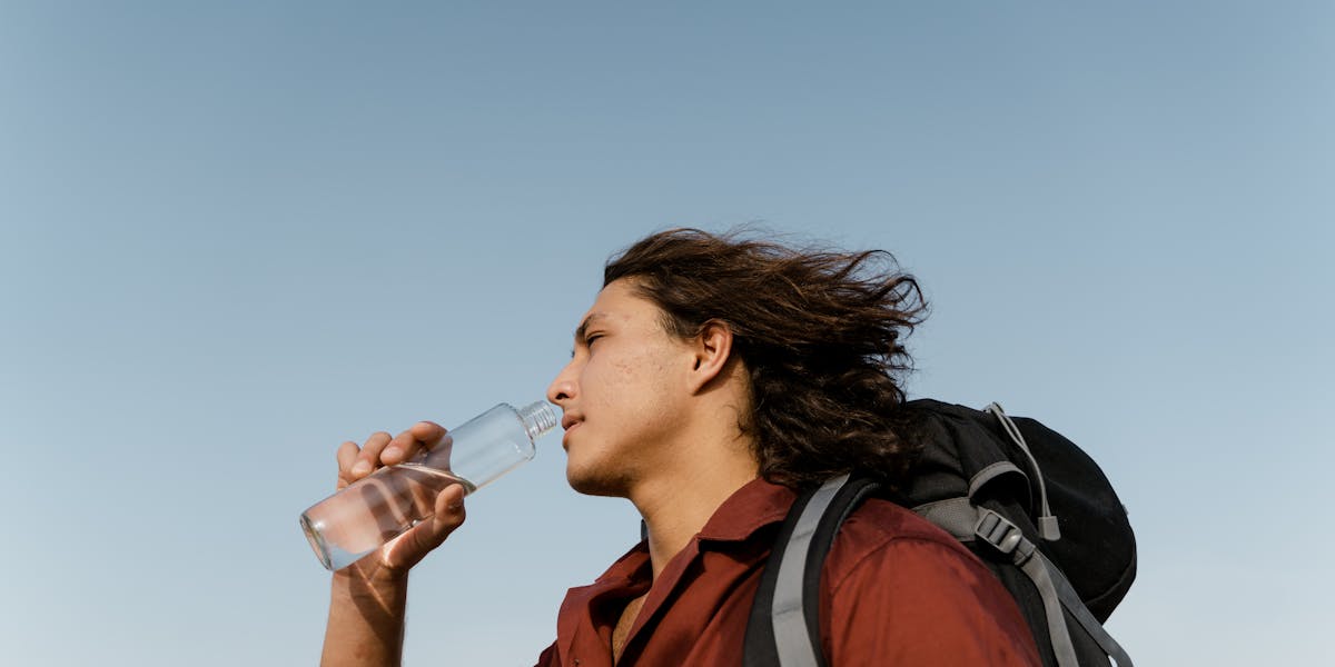 Four beige tanks in an outdoor water treatment setup with blue piping.