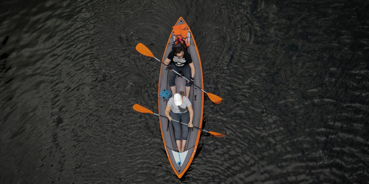 Drone shot of a couple kayaking peacefully on a calm lake, perfect for adventure s...