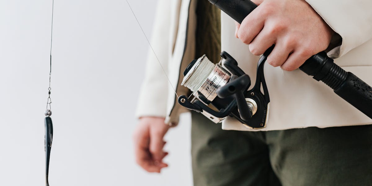 Collection of fishing rods beside a bait rental sign outdoors.