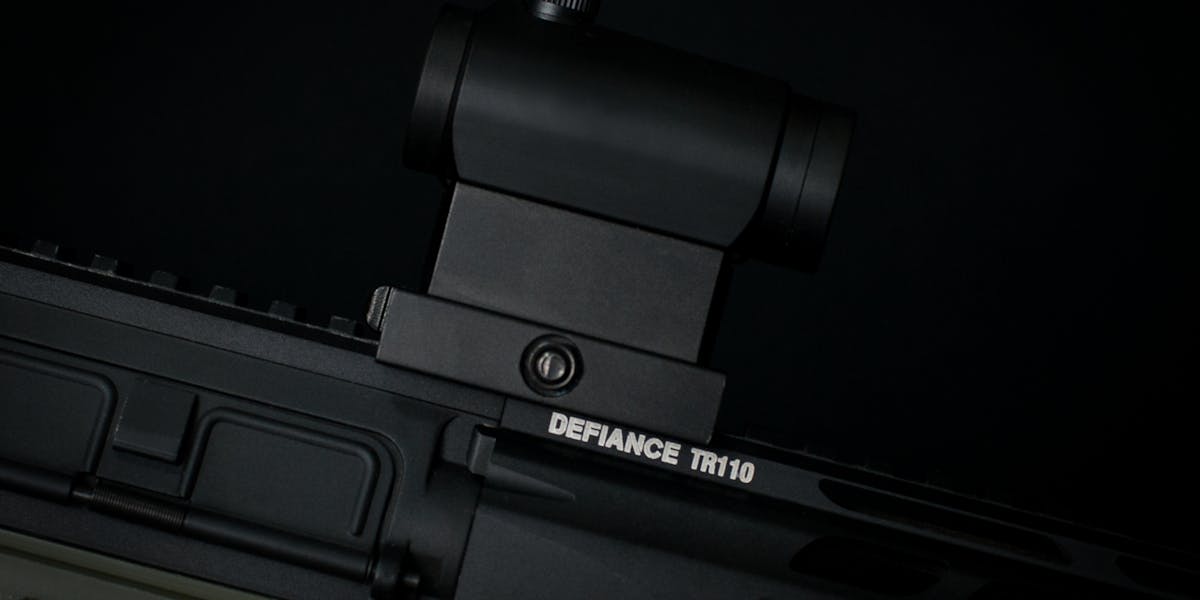 Detailed view of a rifle scope mounted on a tactical firearm, showcasing precisi