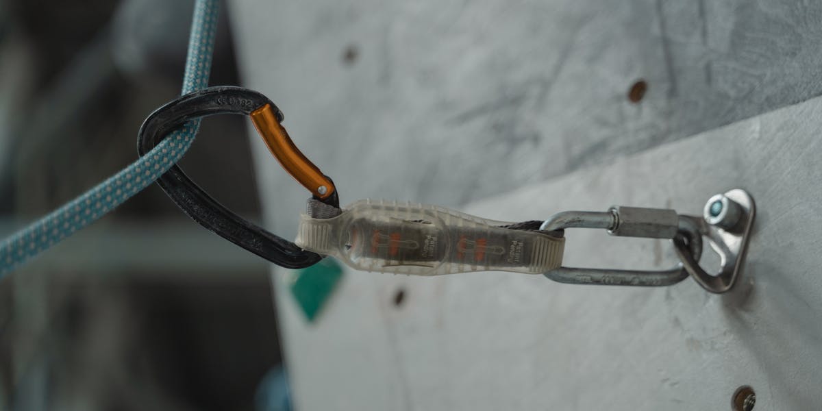 Detailed close-up of climbing gear and carabiner attached to a climbing wall, sh