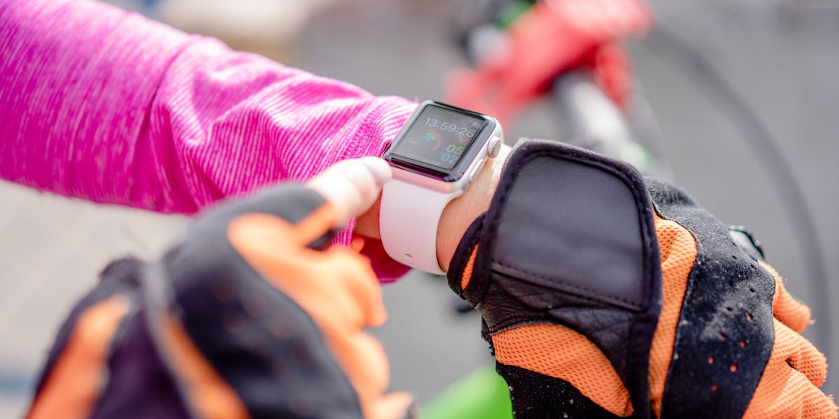 Close-up of a man in athletic wear adjusting a smartwatch, showcasing fitness an
