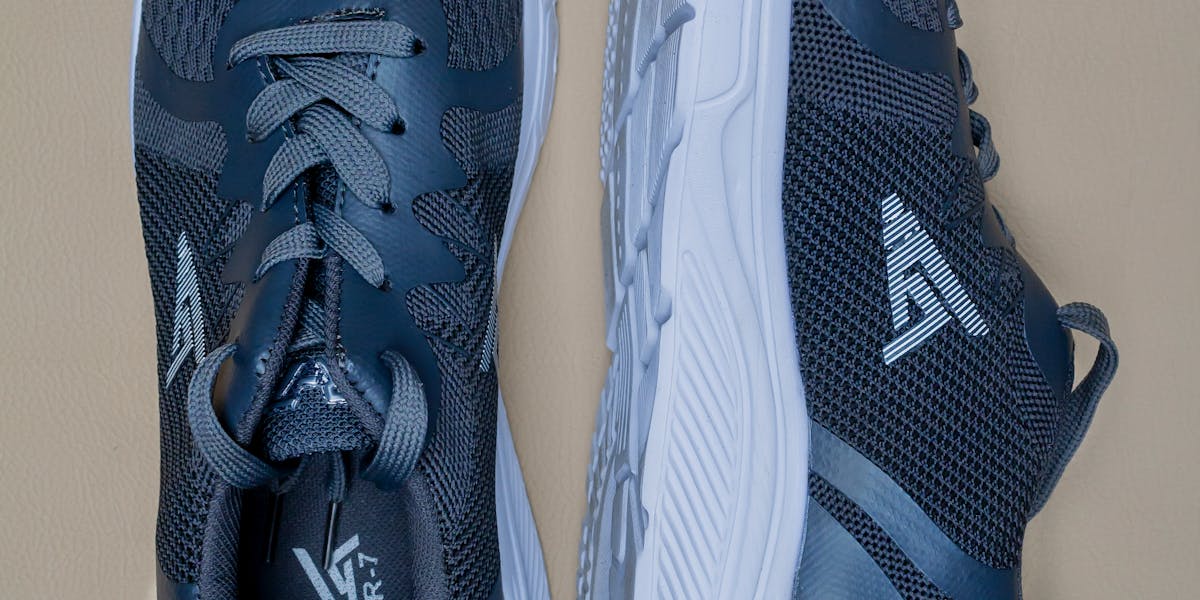 Close-up of blue athletic sneakers on a beige surface, highlighting style and de