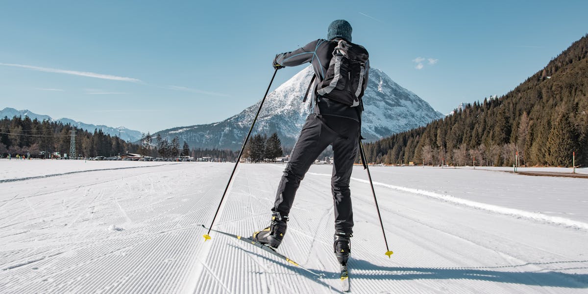 Skier enjoying cross-country skiing in beautiful Tirol, Austria, framed by snowy m...