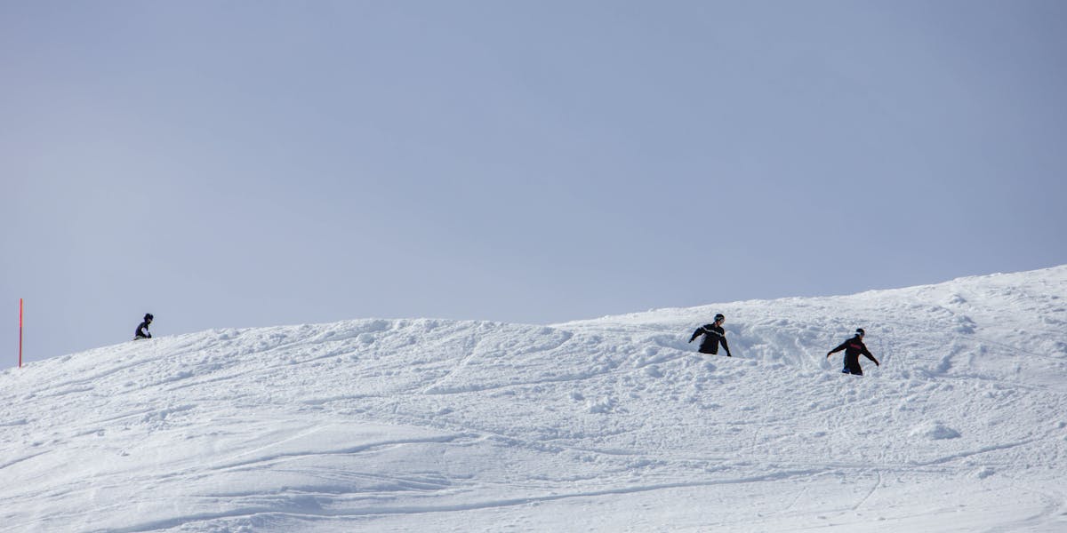 Black and white image of skiers descending a snowy mountain slope capturing winter...