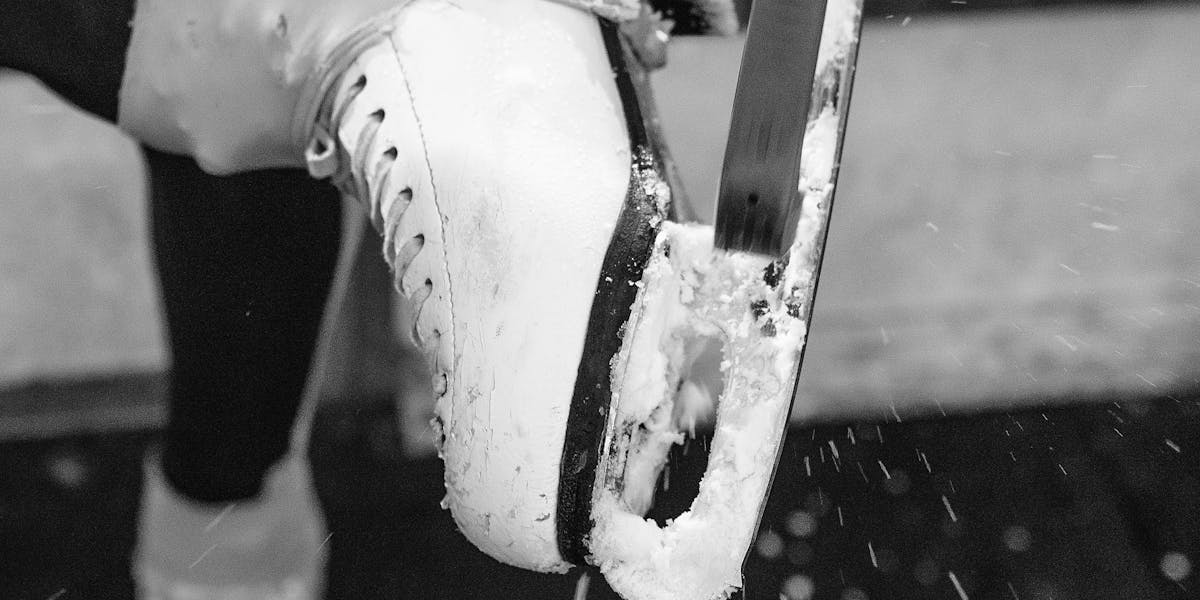 Artistic grayscale photo of ice skates being cleaned, highlighting winter sports