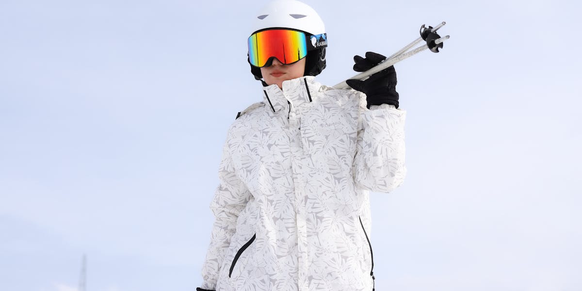 Person in bright winter clothing standing in a snowy landscape with fog and mist