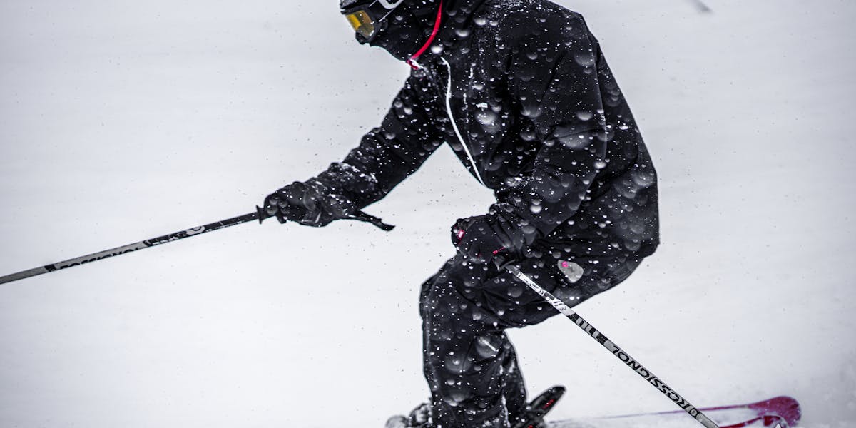 Man skiing on a snowy mountain slope at a ski resort in winter.