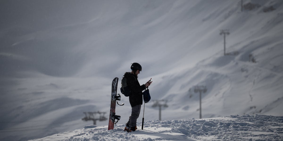 A snowboarder stands ready on a sunny slope in Laax snow park, Switzerland.