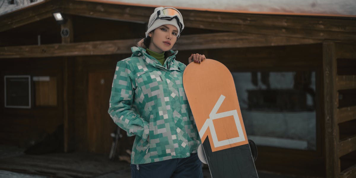 An esthetician wearing gloves stirring purple wax in a wax pot indoors.