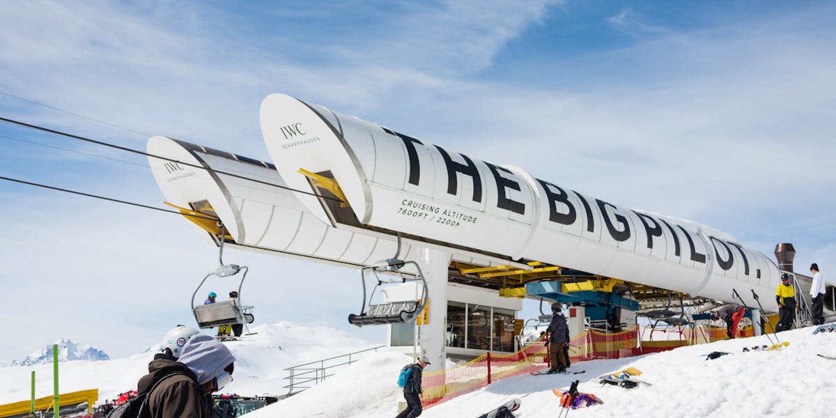 Skier navigating snowy terrain at a winter resort surrounded by snow-covered tre