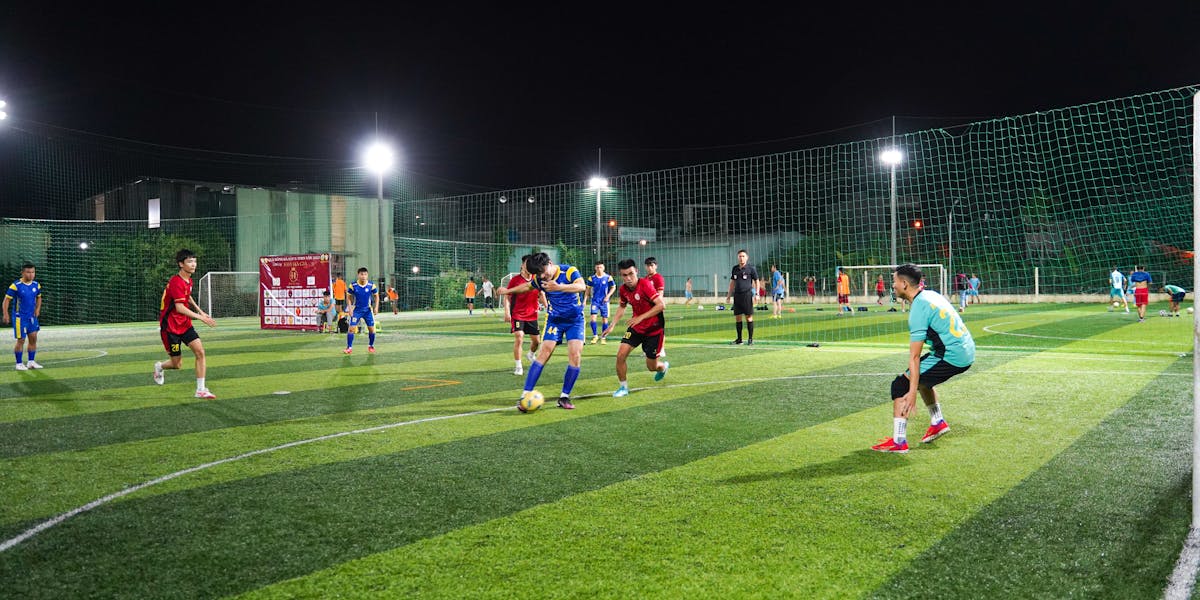 Action shot of teenage girls playing futsal indoors, showcasing teamwork and com
