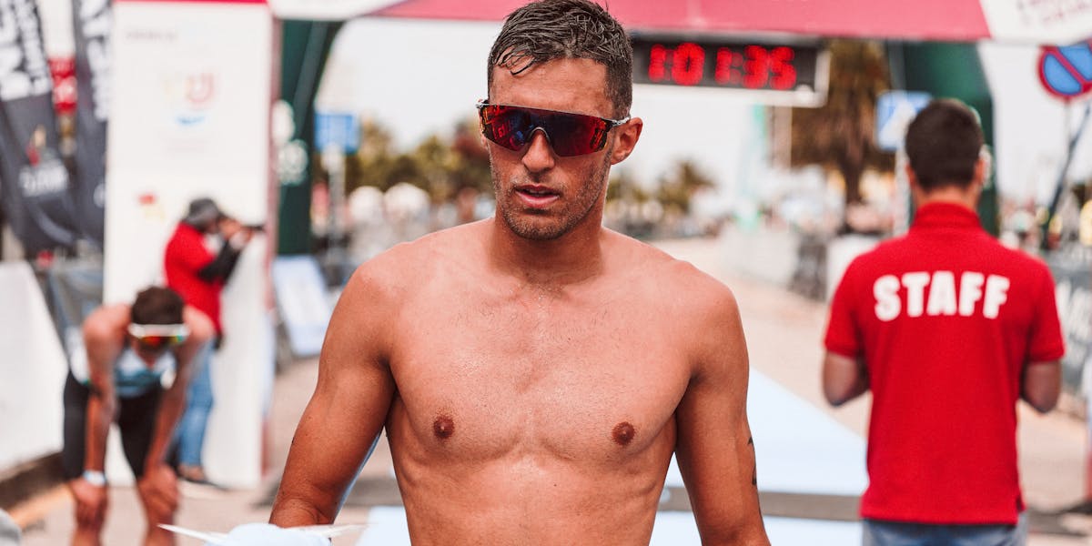 Triathlete crosses the finish line at the Triatlo de Oeiras race event.