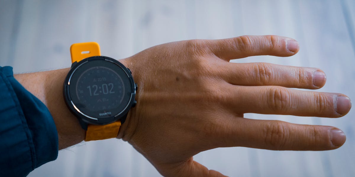 A close-up image of a smartwatch with a yellow strap worn on a wrist, displaying t...