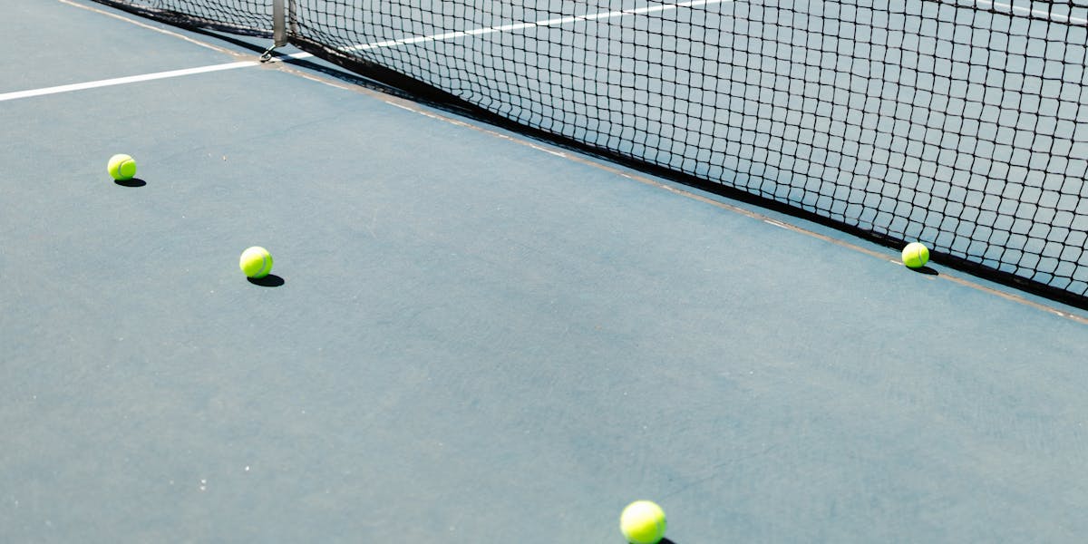 Detailed close-up of yellow tennis balls on a rustic wooden surface with textured ...